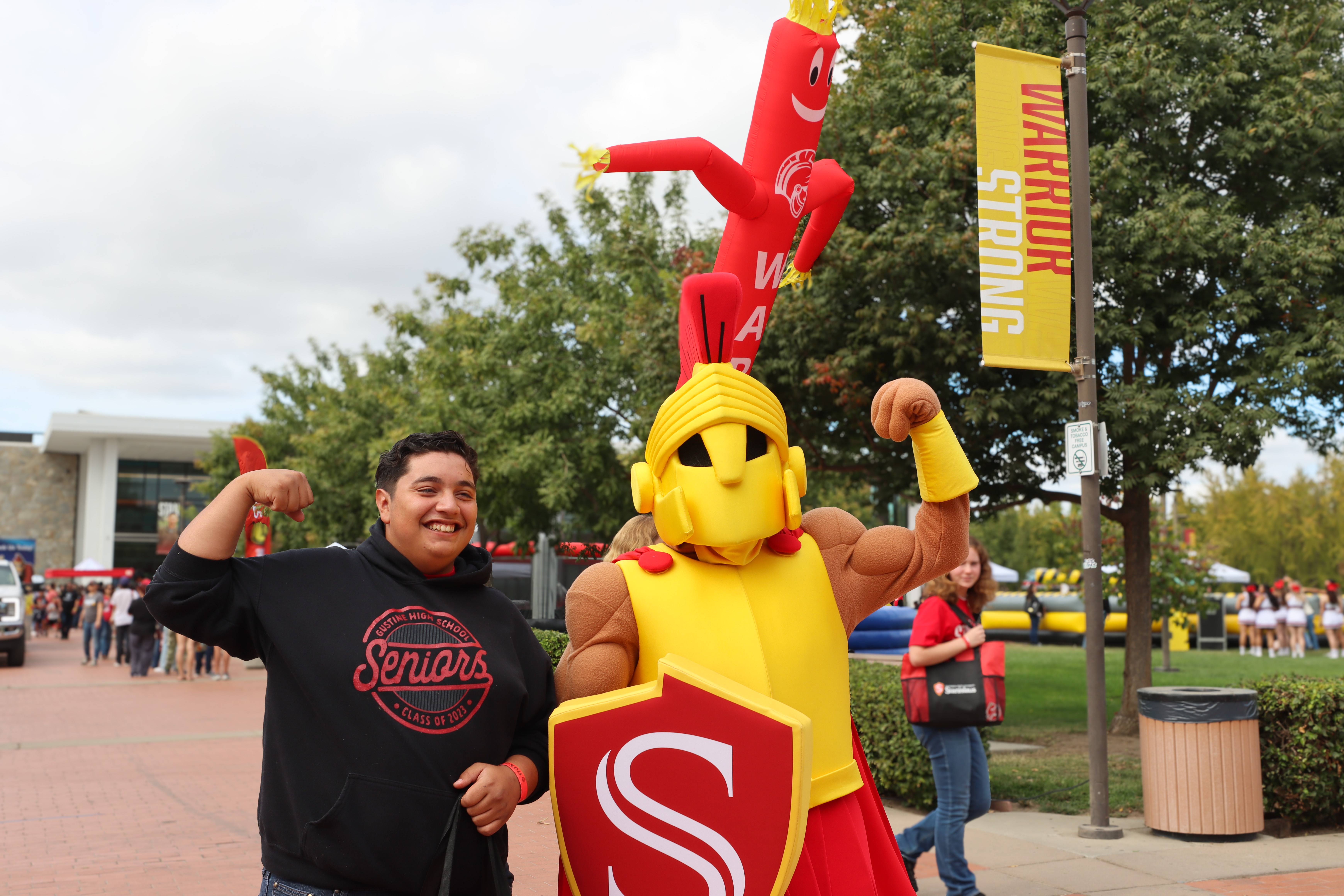 A student stands beside Titus the Warrior, stan states mascot, at the warrior exp.