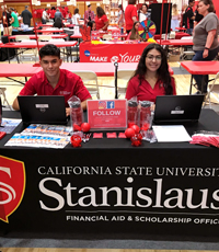 Student assistants table at an event with financial aid information