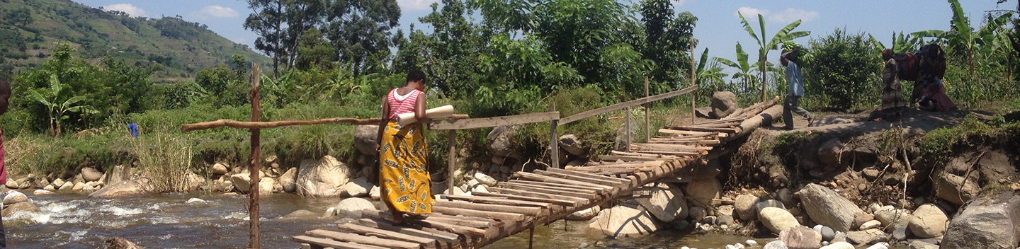 A woman crosses a bridge in Uganda.