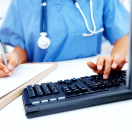 A nurse types away on a keyboard