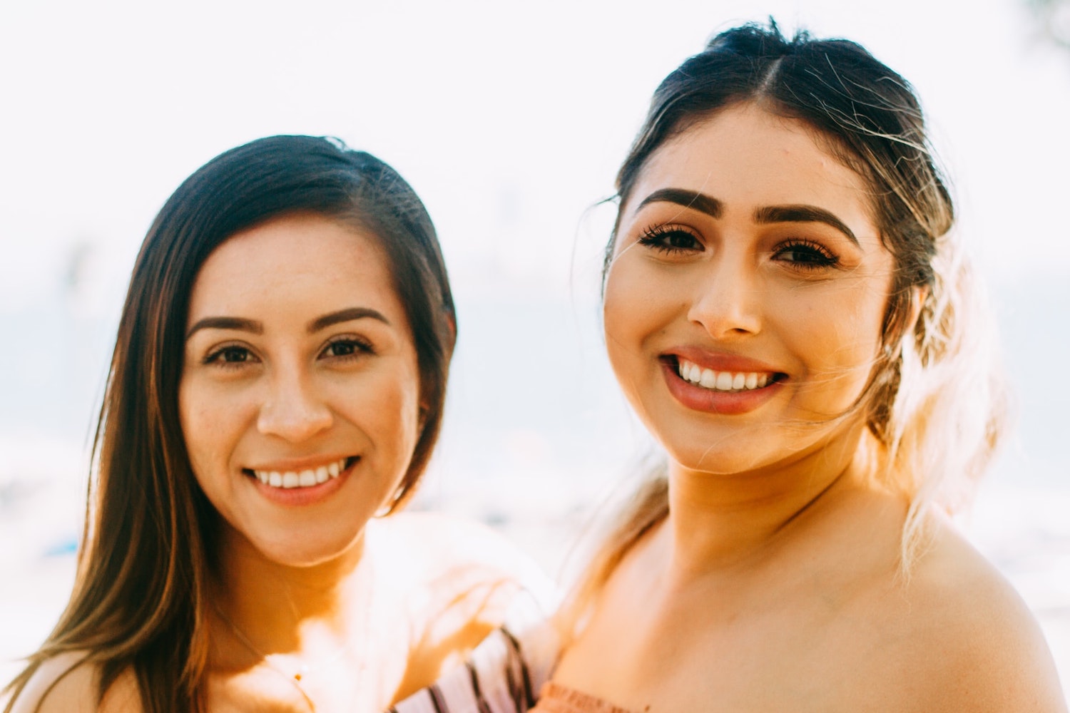 Two women smiling for a picture. 