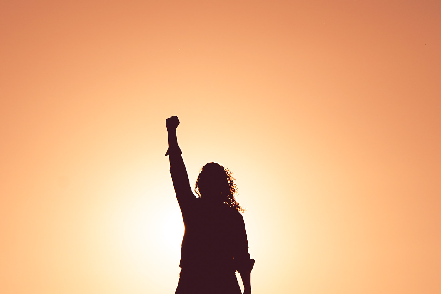 Silhouette of woman with her arm raised. 
