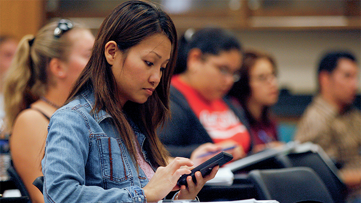 Student taking notes in lecture class.