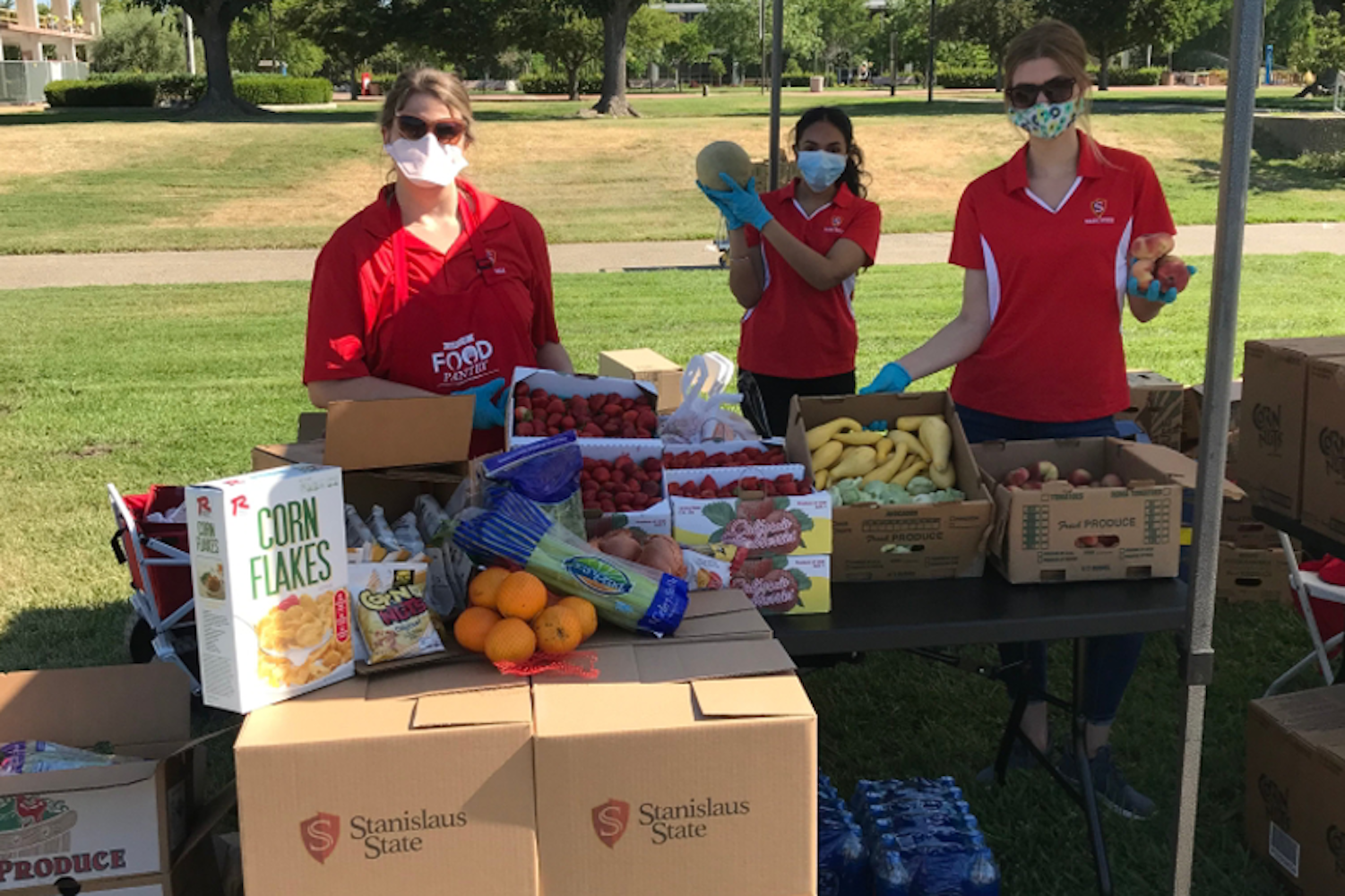 Image of staff members with boxes of fresh produce and food boxes to distribute.