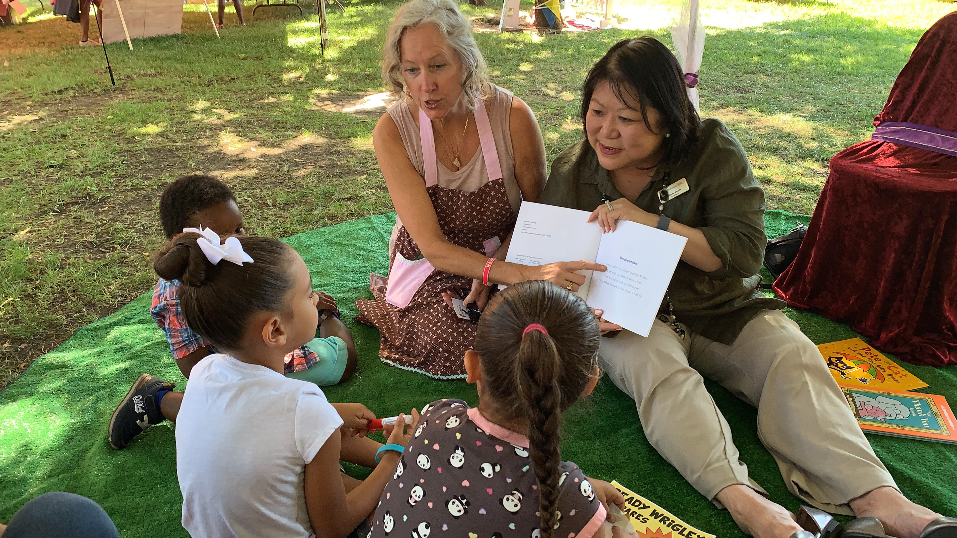 Stanislaus State President Ellen Junn and a helper read to children at a previous Family Day at the Park.