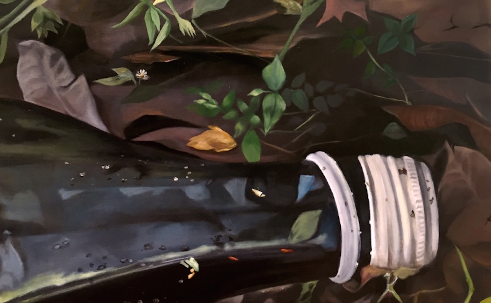 A bottle laying on top of leaves