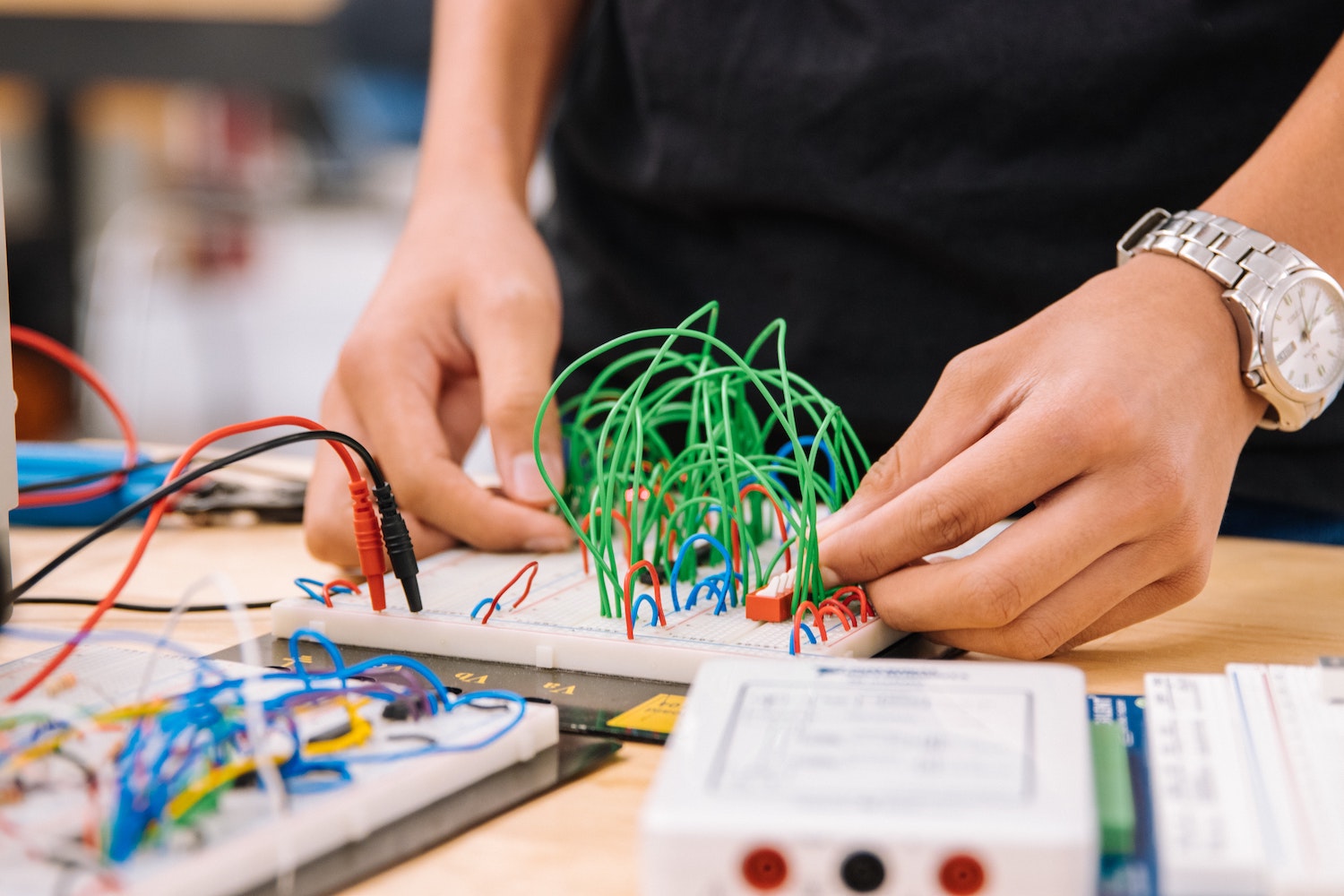 Two hands adjusting wires attached to a board