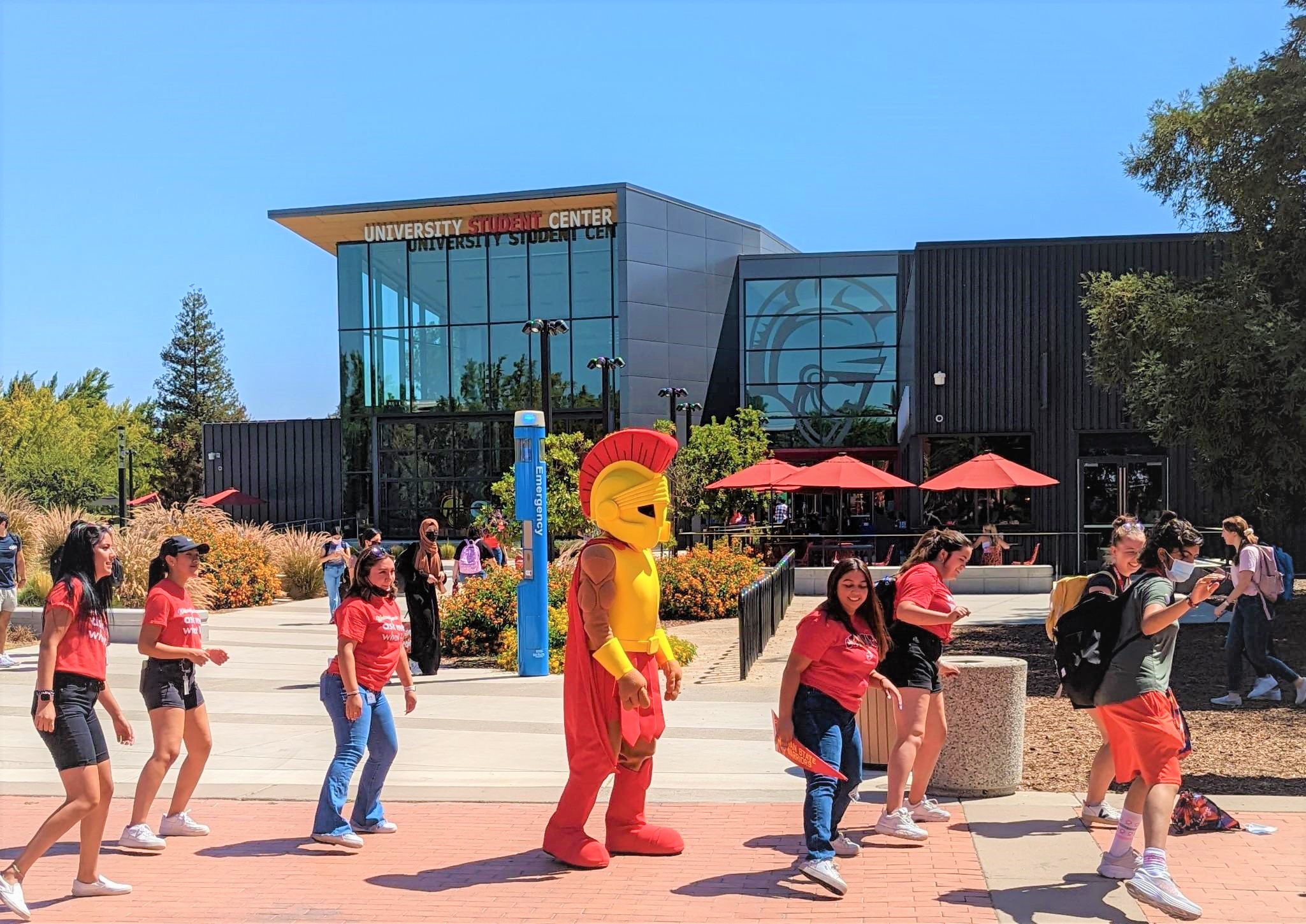 Photo of student center with students lined up to dance and Titus, the campus mascot, in the middle.