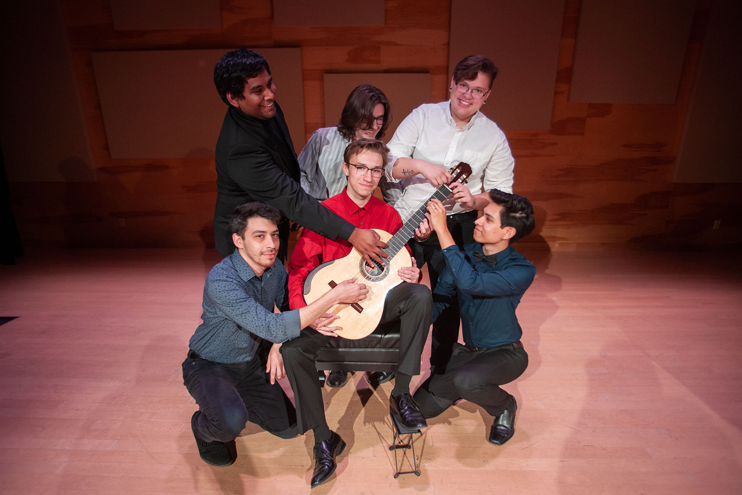 students holding a guitar