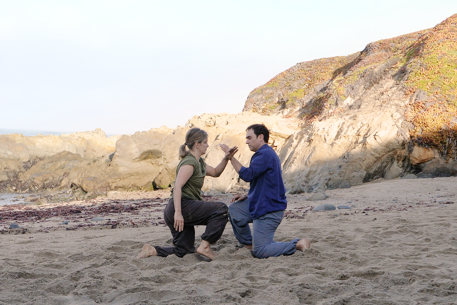 boy and girl kneeling on sand