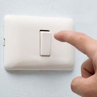 Hand turning off a light switch