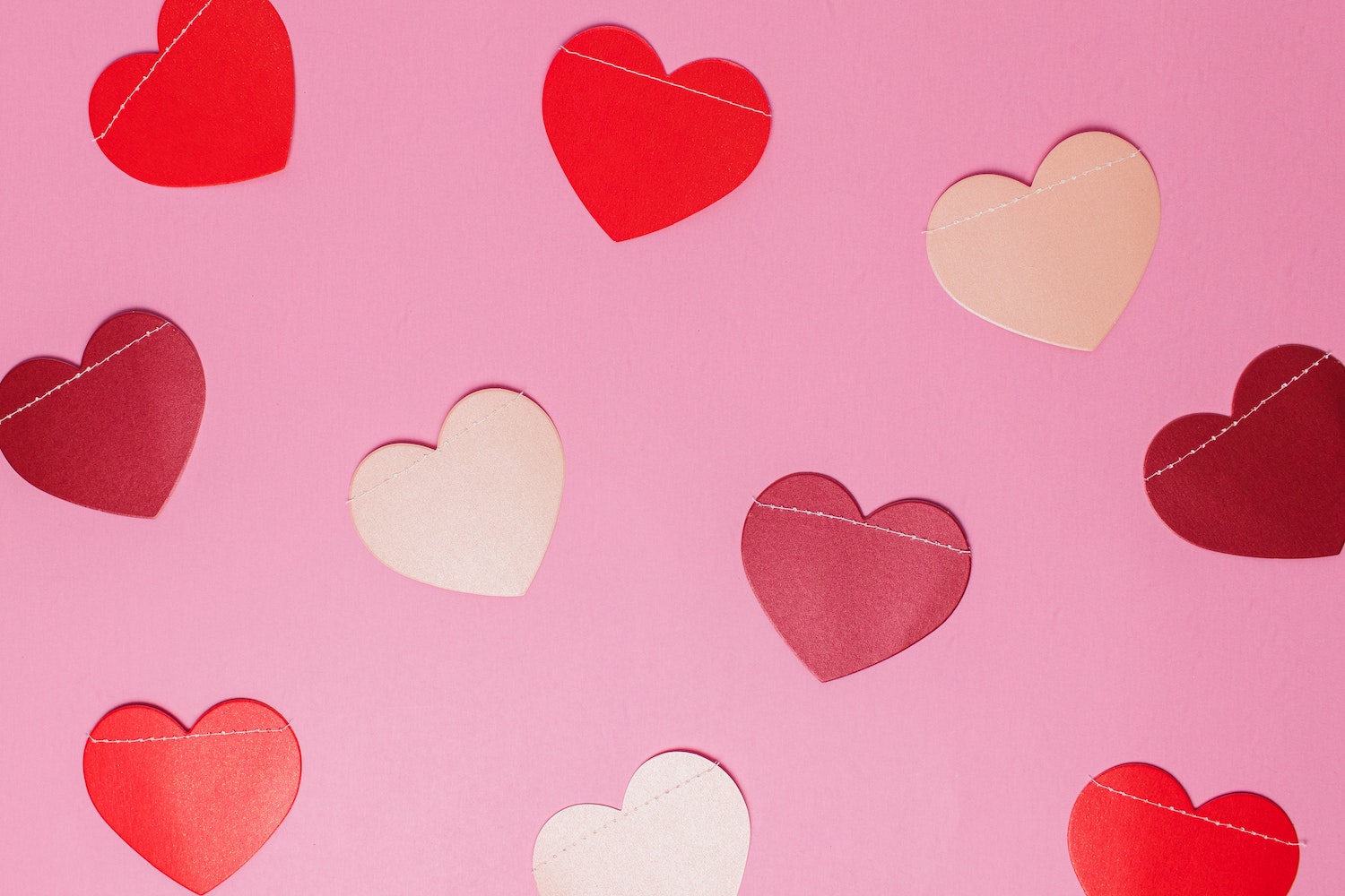 Pink and red hearts spread across a pink background