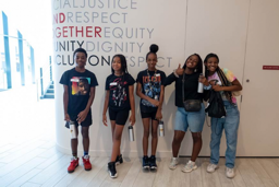 group of students in front of diversity wall