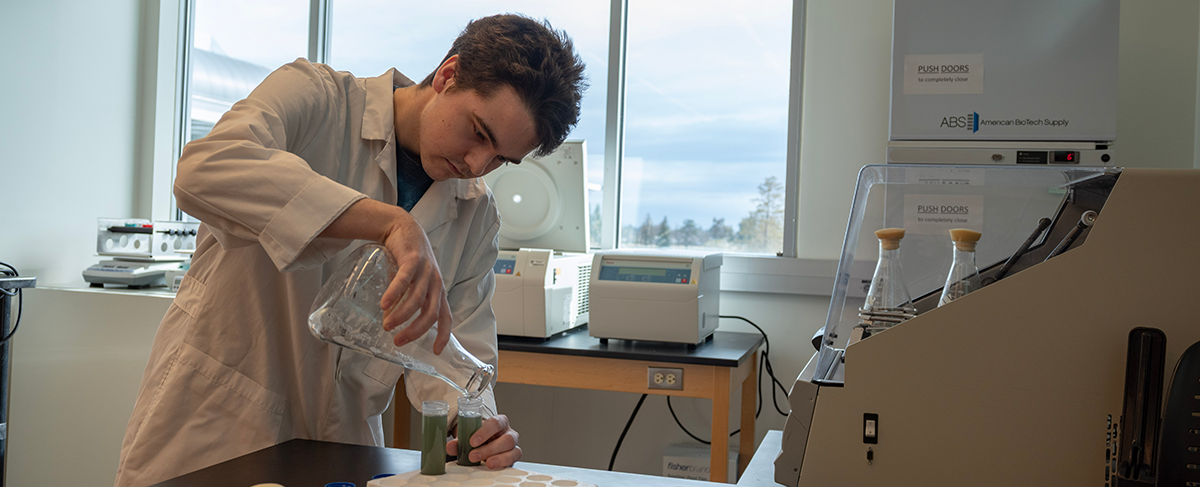 Eli Frazer uses some equipment while working in a science lab.