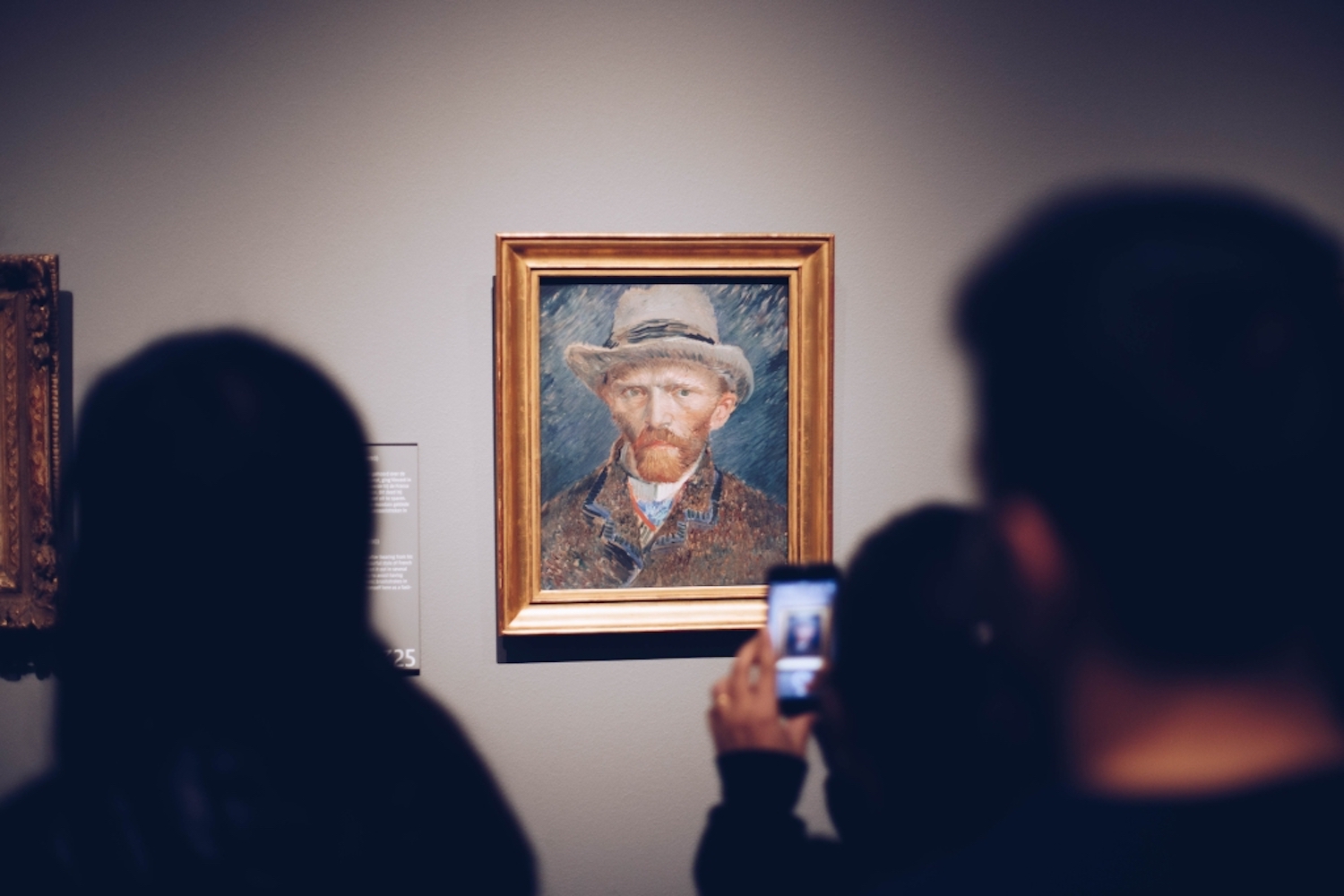 People looking at a portrait of Van Gogh