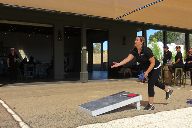 Member playing corn hole game