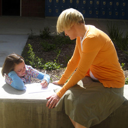 Student and a teacher working on writing