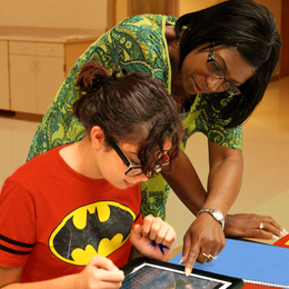 A student and a teacher working on a tablet