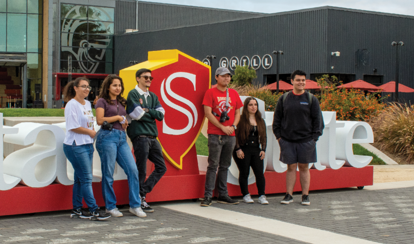 welcoming-warriors.png A group of students pose in front of a large Stan State photo prop.