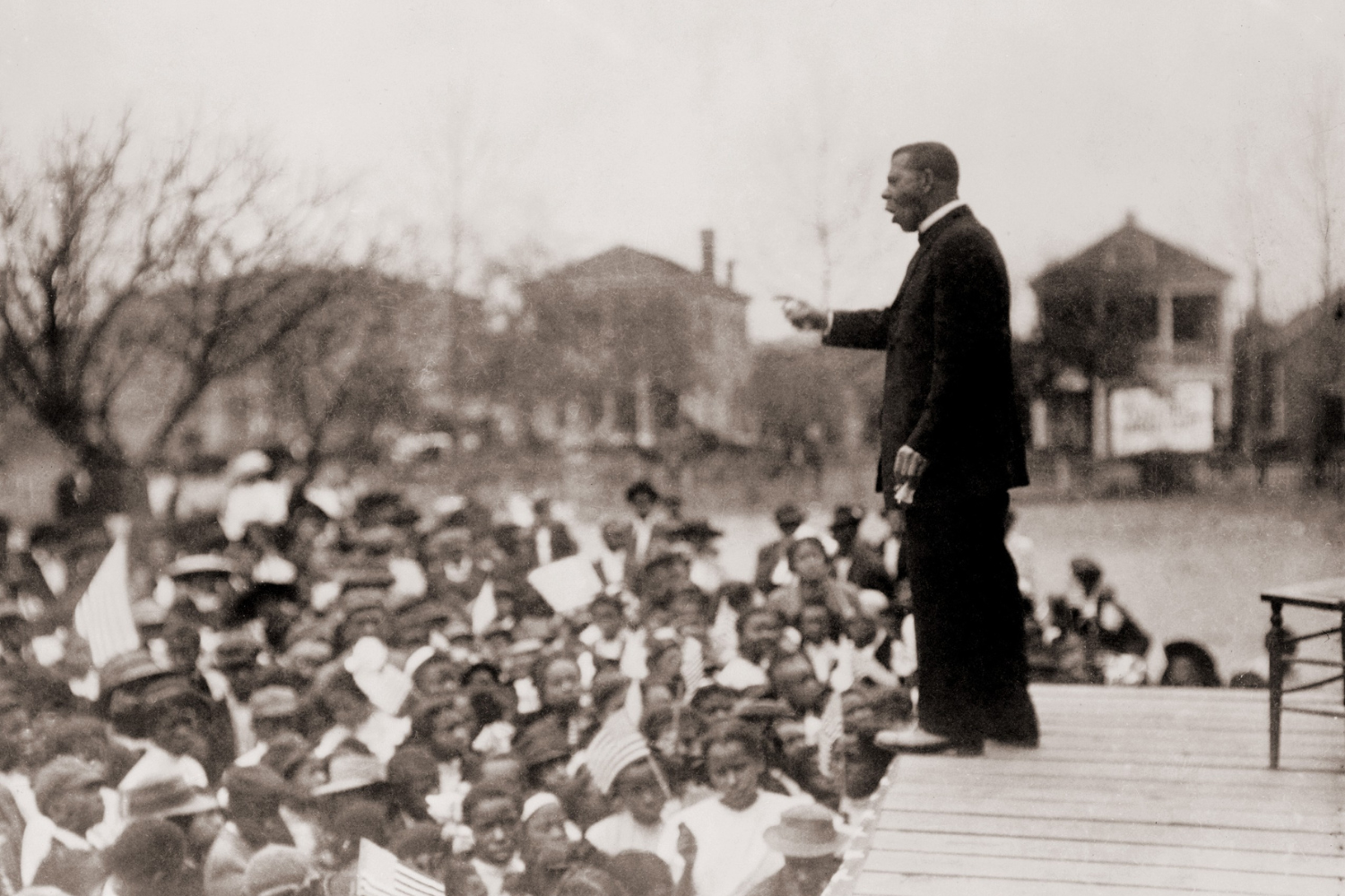 a man on stage giving a speach to a large crowd.