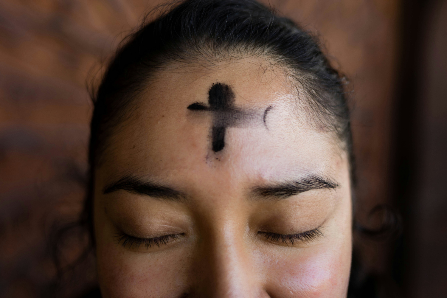woman with black ash cross on her forehead