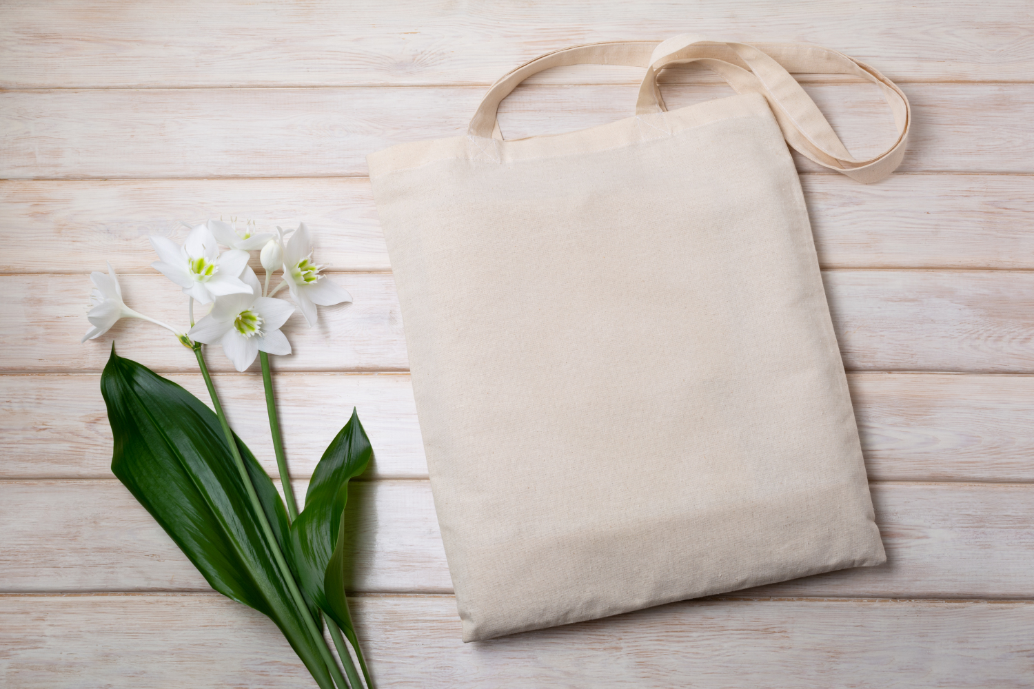 a reusable shopping bag next to a flower