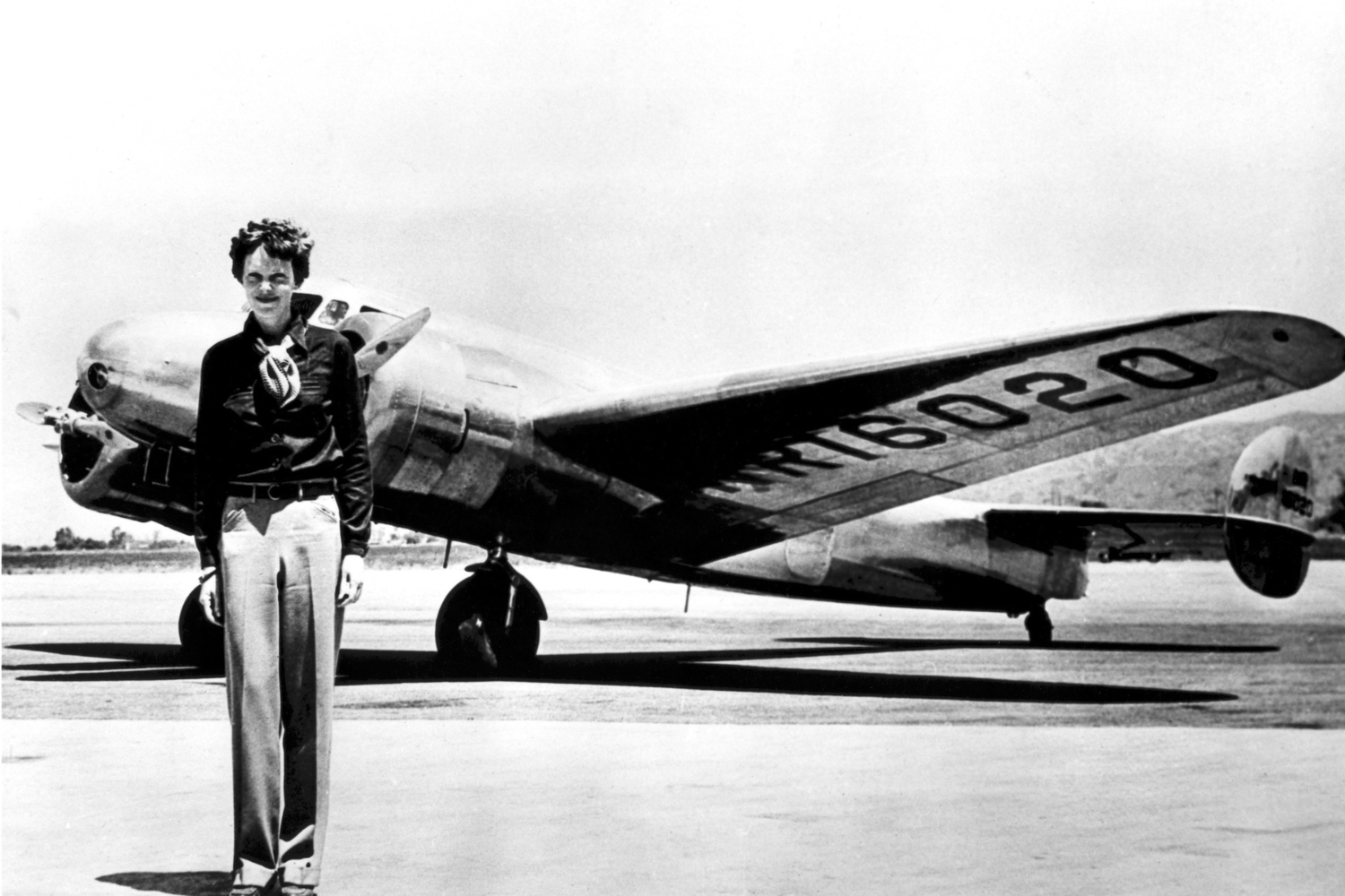 Amelia Earhart standing in front of her plane. 