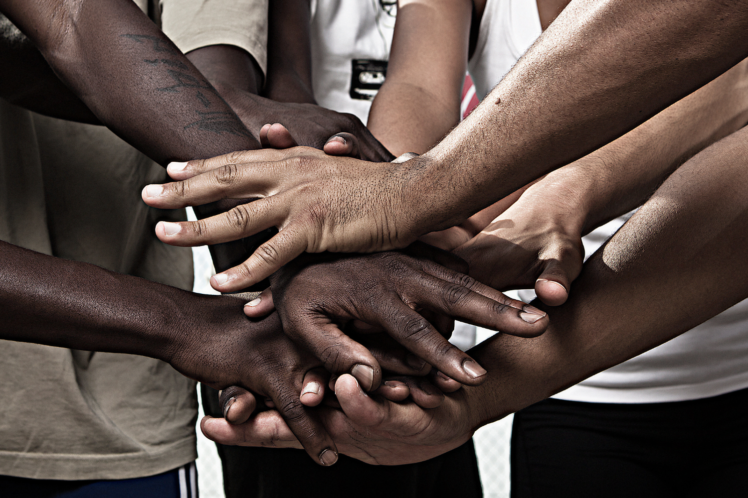 a close up view of a group of hands breaking after a meeting. 