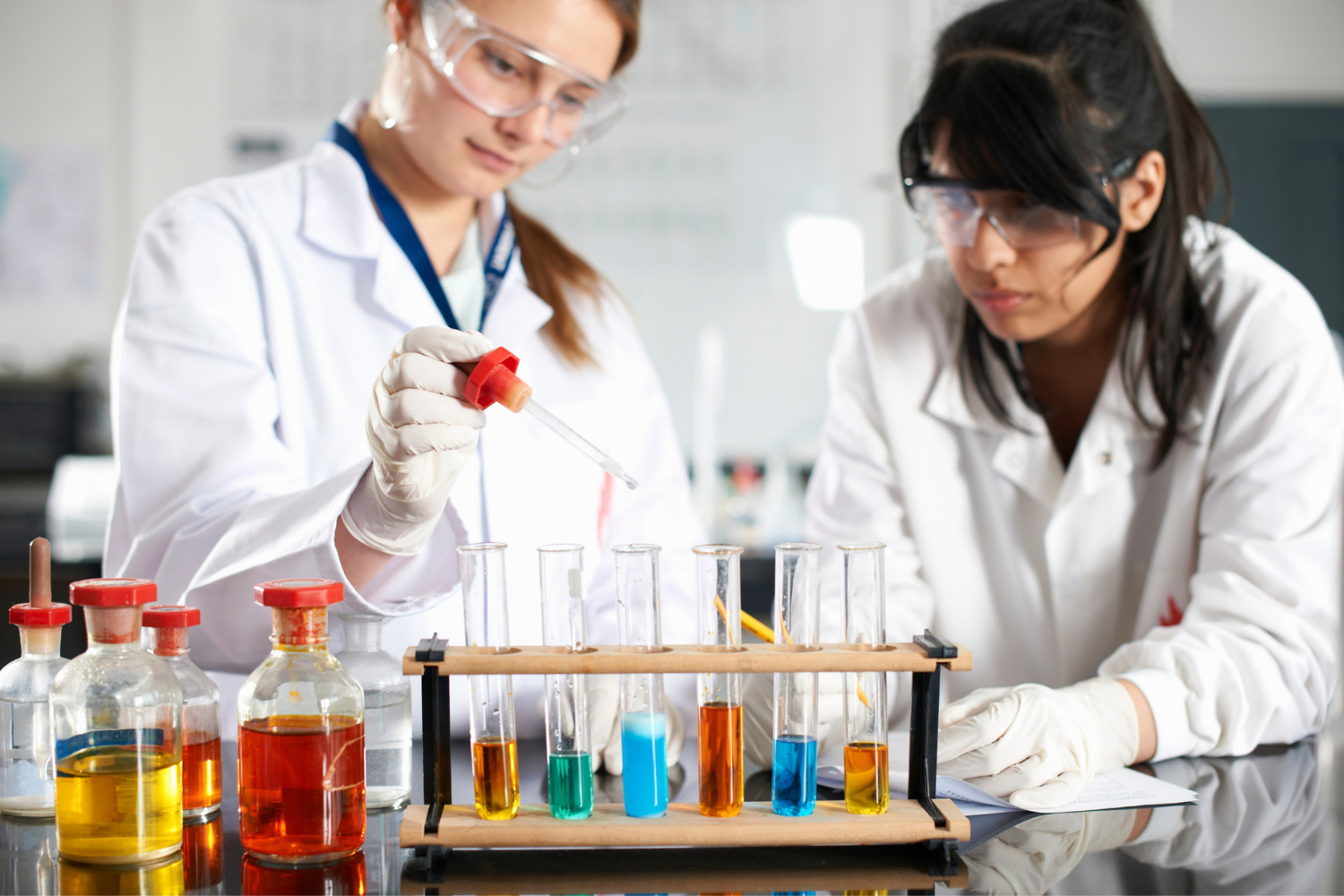 two scientists examining beakers in a chemistry lab