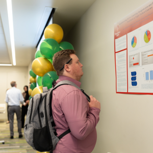 Student reads a presentation poster at the RSCA event.