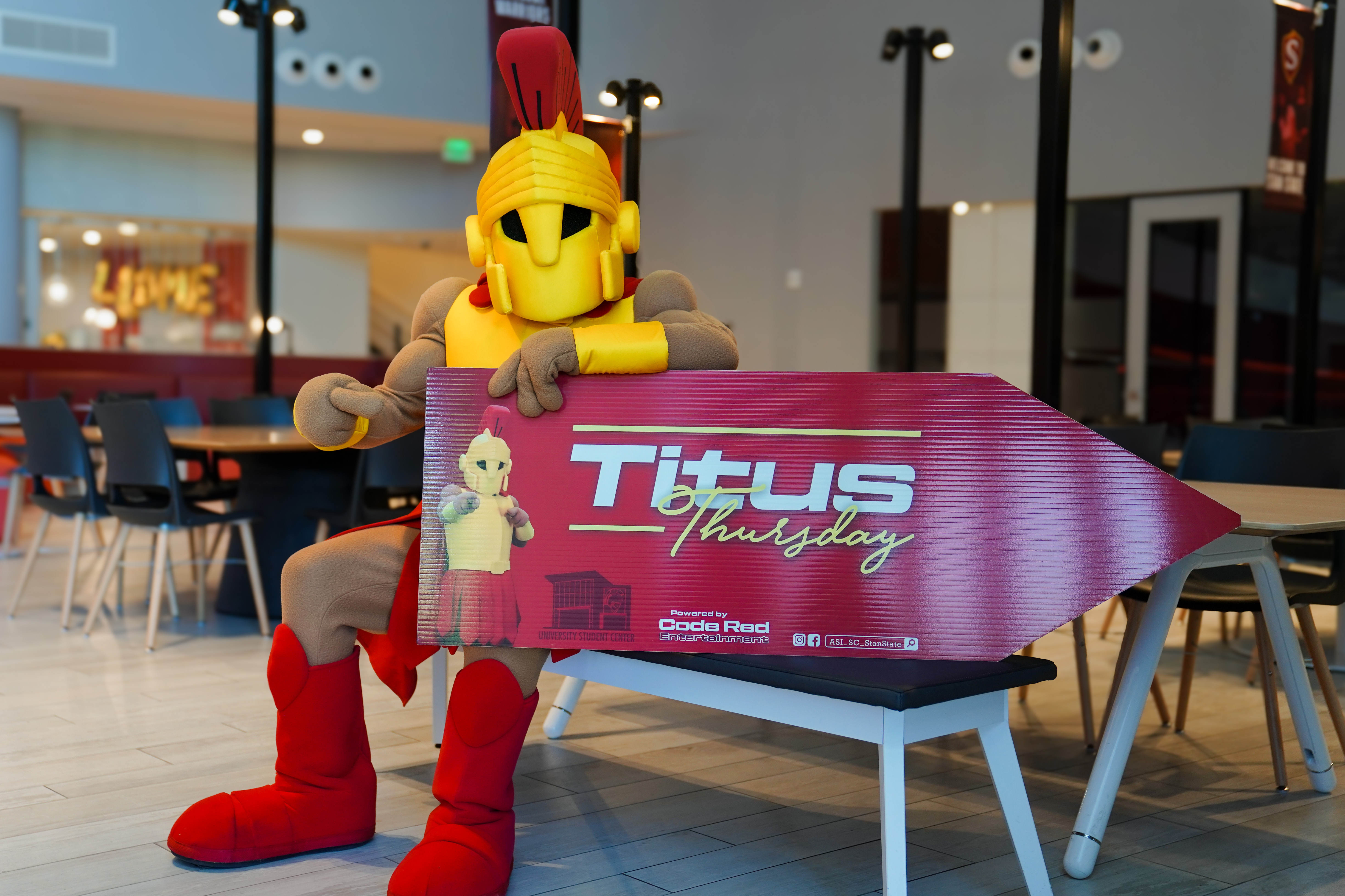 titus mascott holding sign