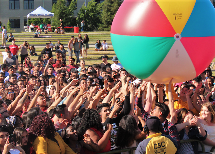 Crowd of Stuednts hitting giant beach ball in air