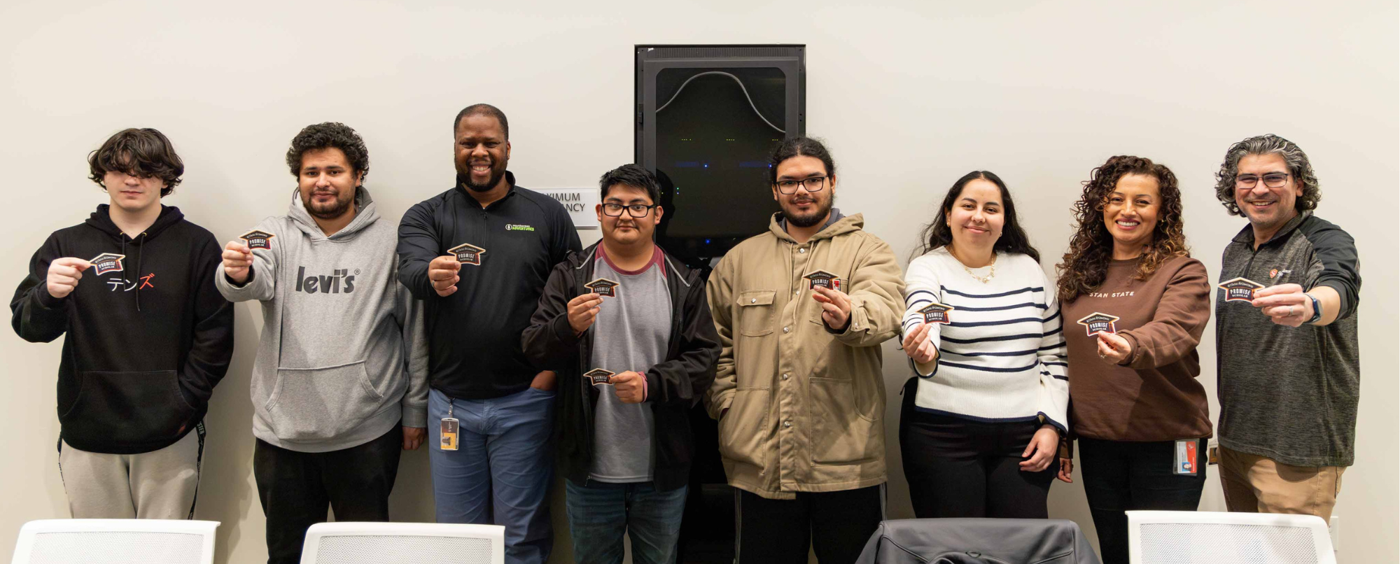 Group of staff and students smiling holding up Promise Scholar stickers