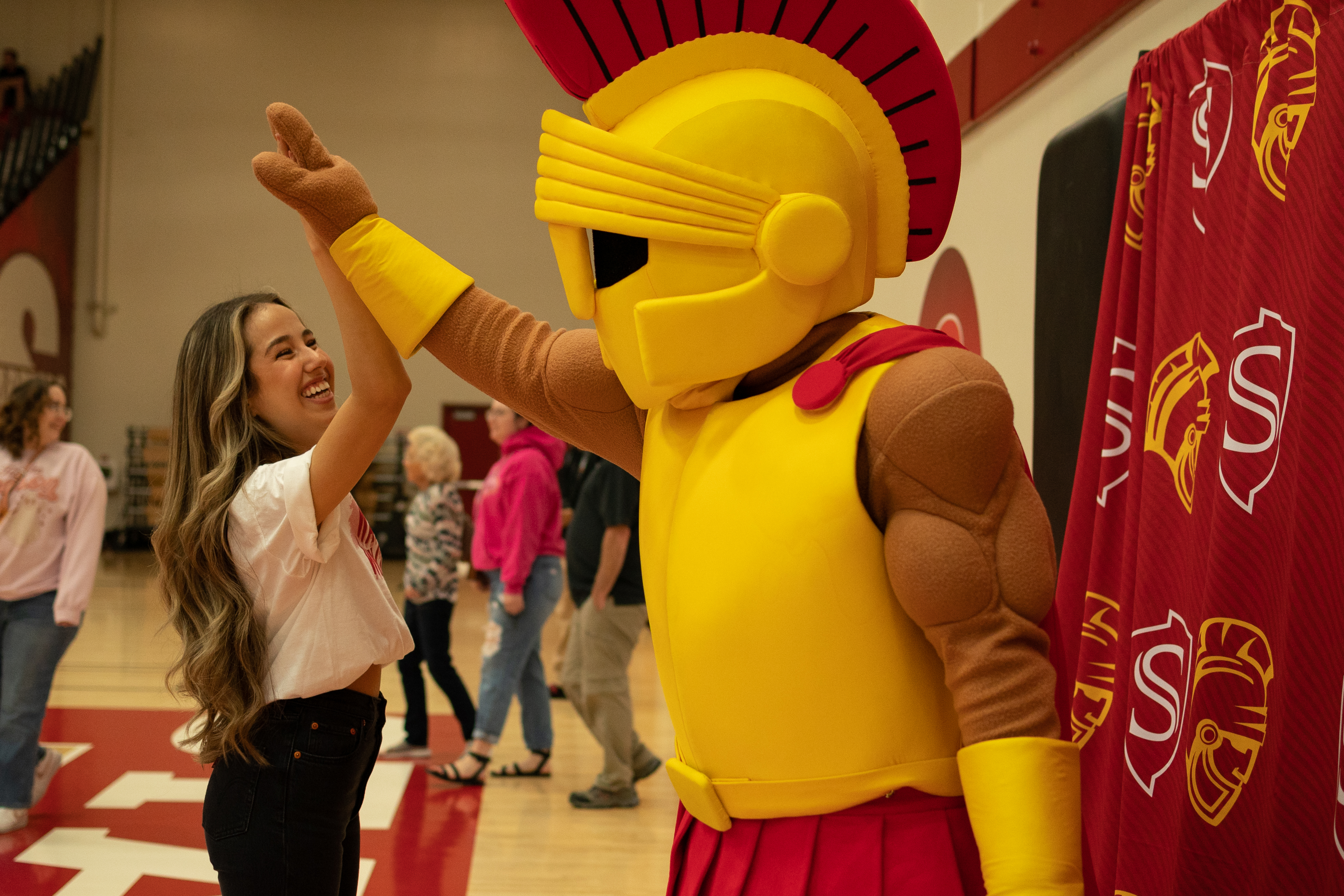 A student high fives Titus the Stan State mascot.