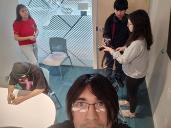 Moises Enriquez snaps a group photo working together on a project for Documentary Videography class.