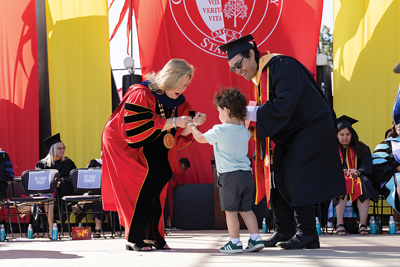 grad with their kid on stage