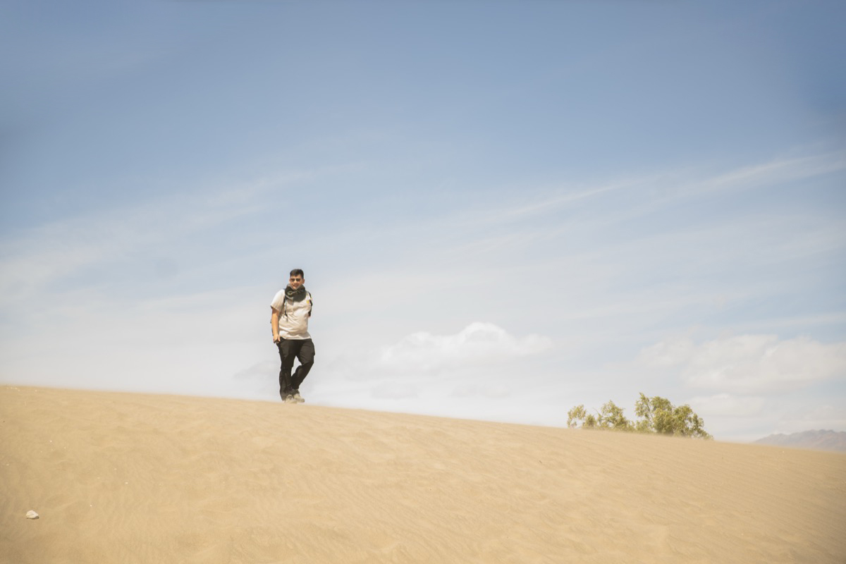 student at the top of a dune mound