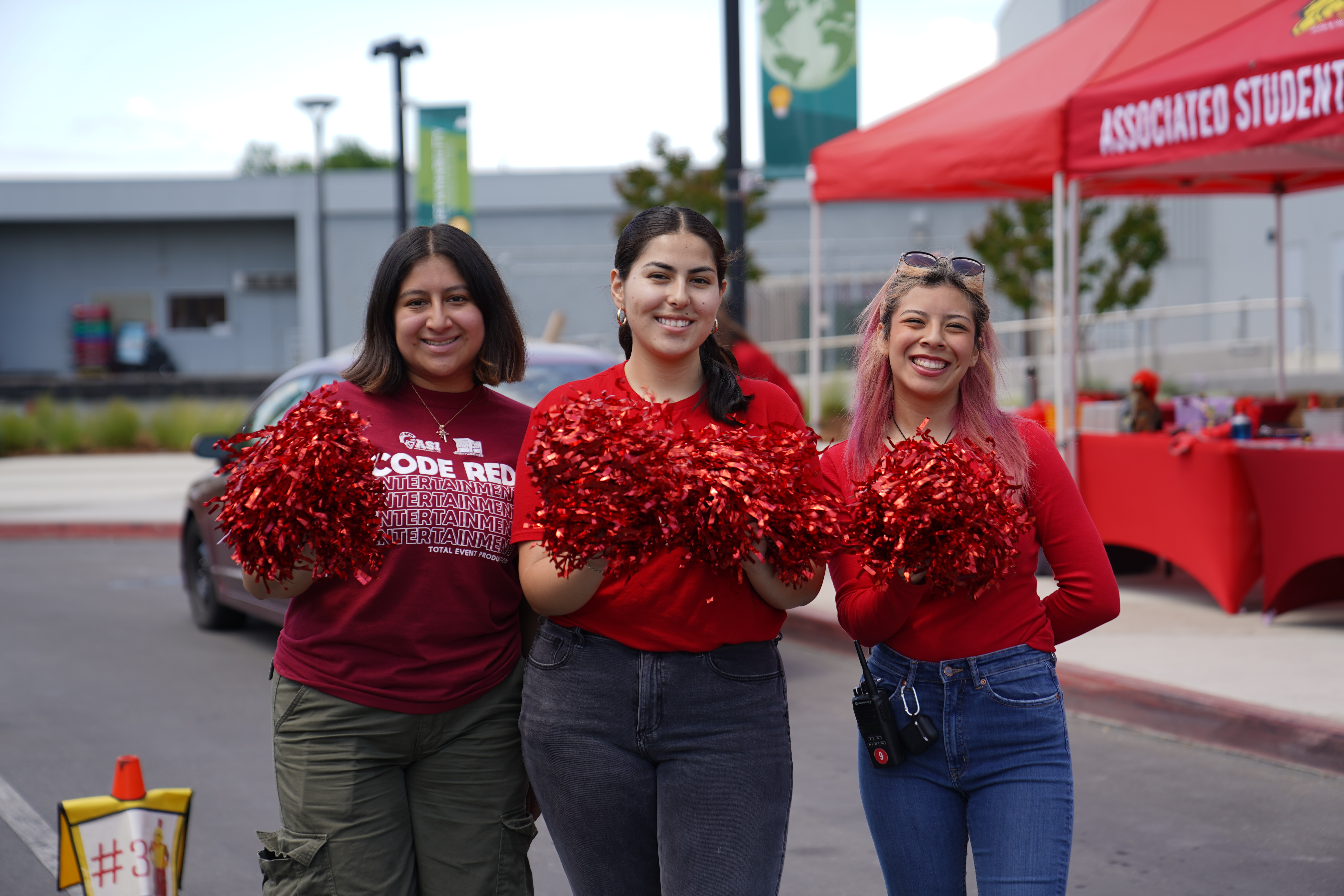 Three students posing with pom poms for Campus Spirit photo.