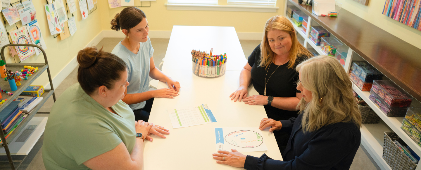 Staff from Jessica's House discuss at a conference table