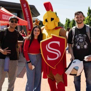 Three students with Titus the mascot at the Quad