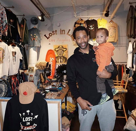 Joel Stallworth holds his child while standing inside 