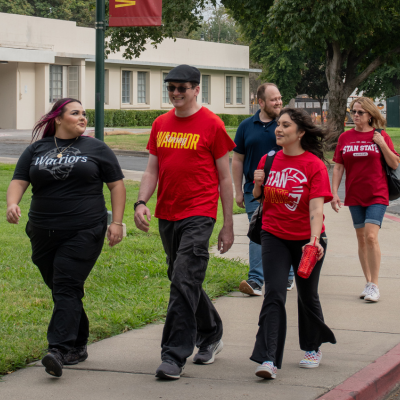 A group of students walks outside the Stockton Campus grounds.
