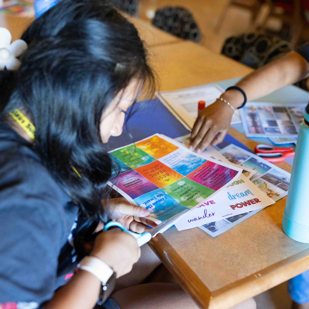 Photo of a student cutting paper for an activity.