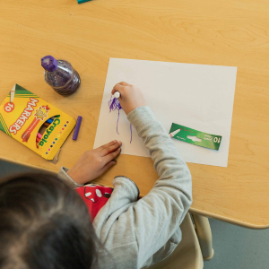 A child doodles on a sheet of paper