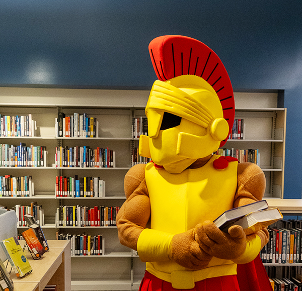 Titus in library holding books
