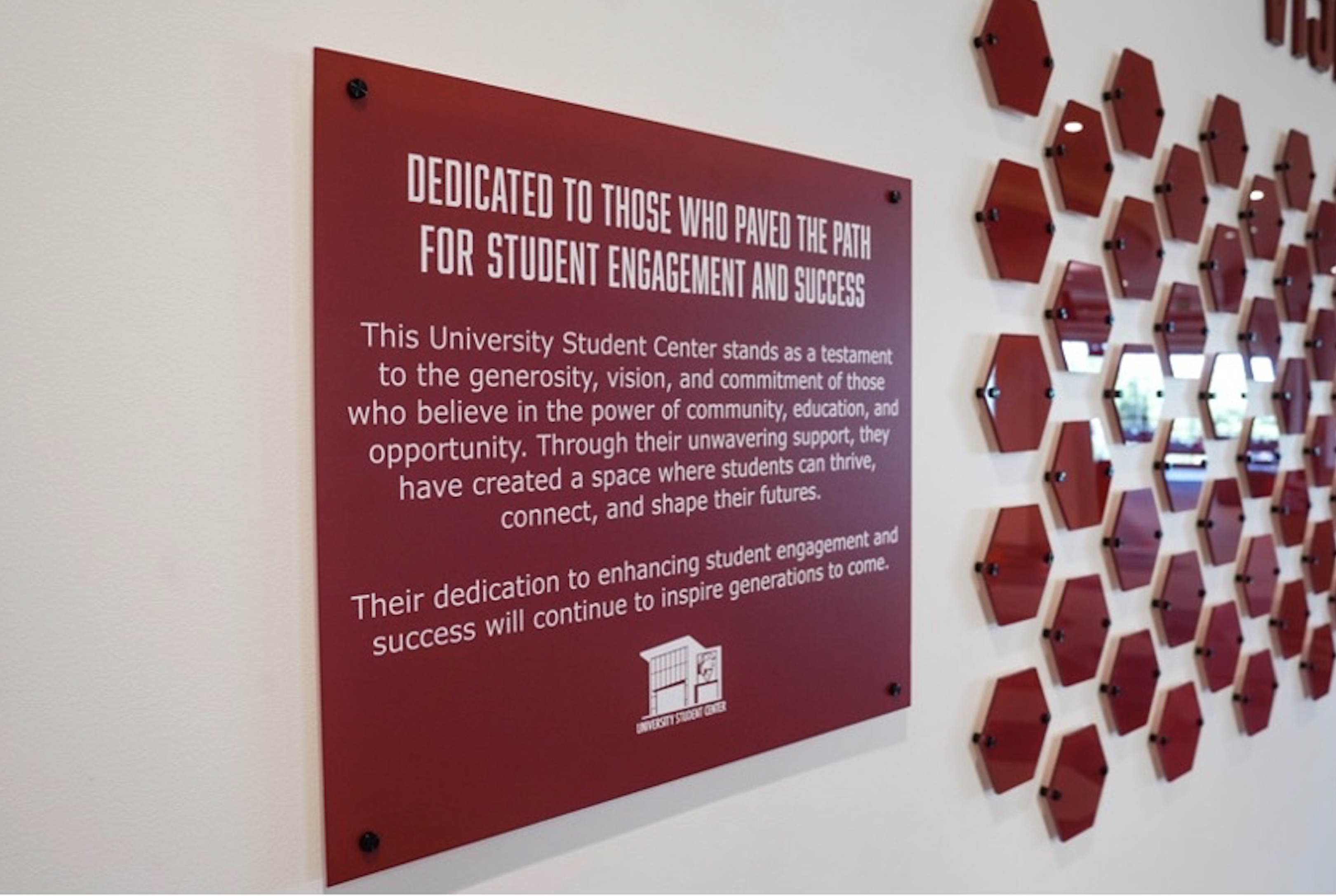 A commemorative plaque for the Visionaries campaign is seen beside the plaque wall in the Student Center