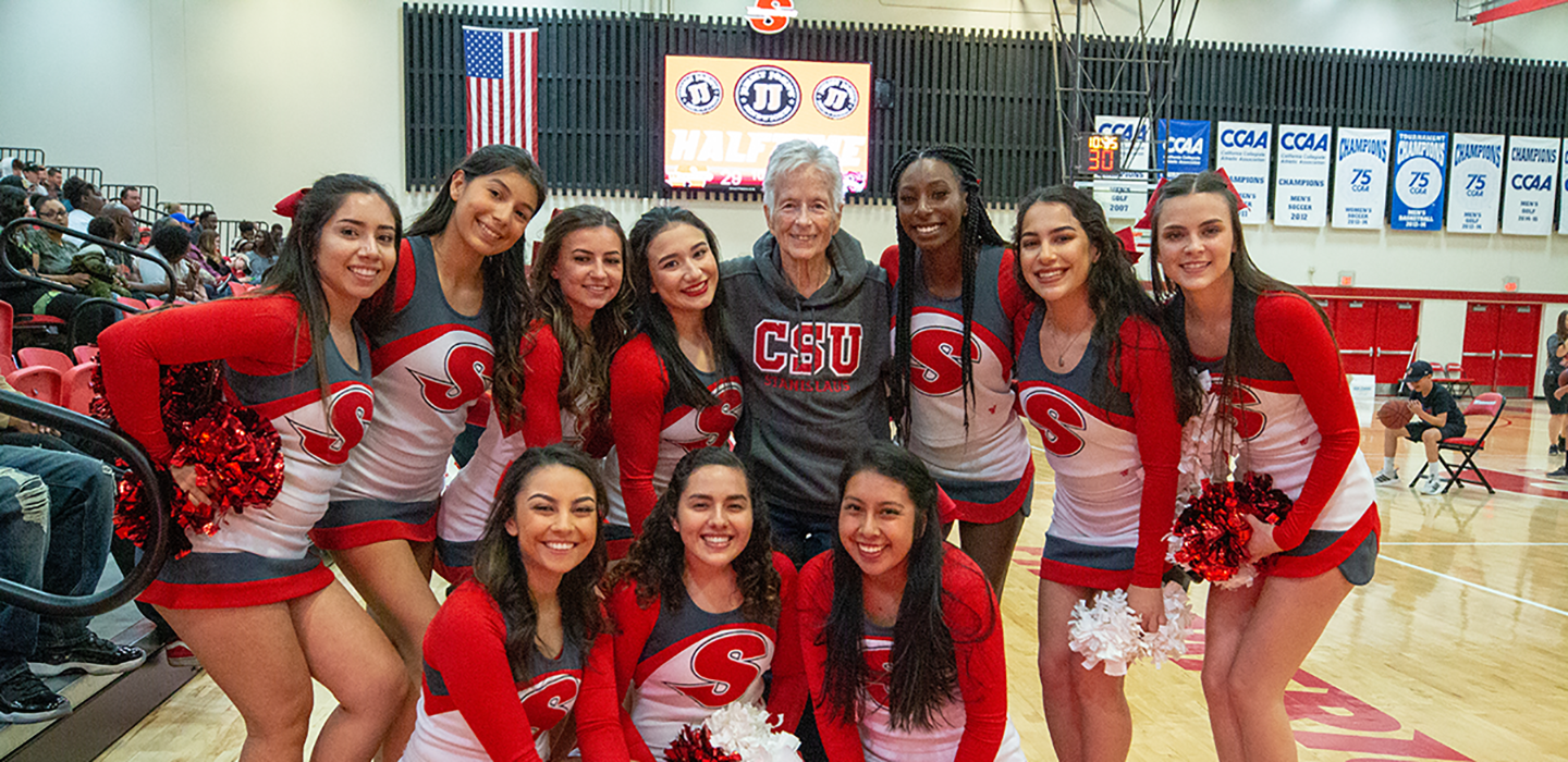 Donna Pierce at a game poses with the cheer squad.
