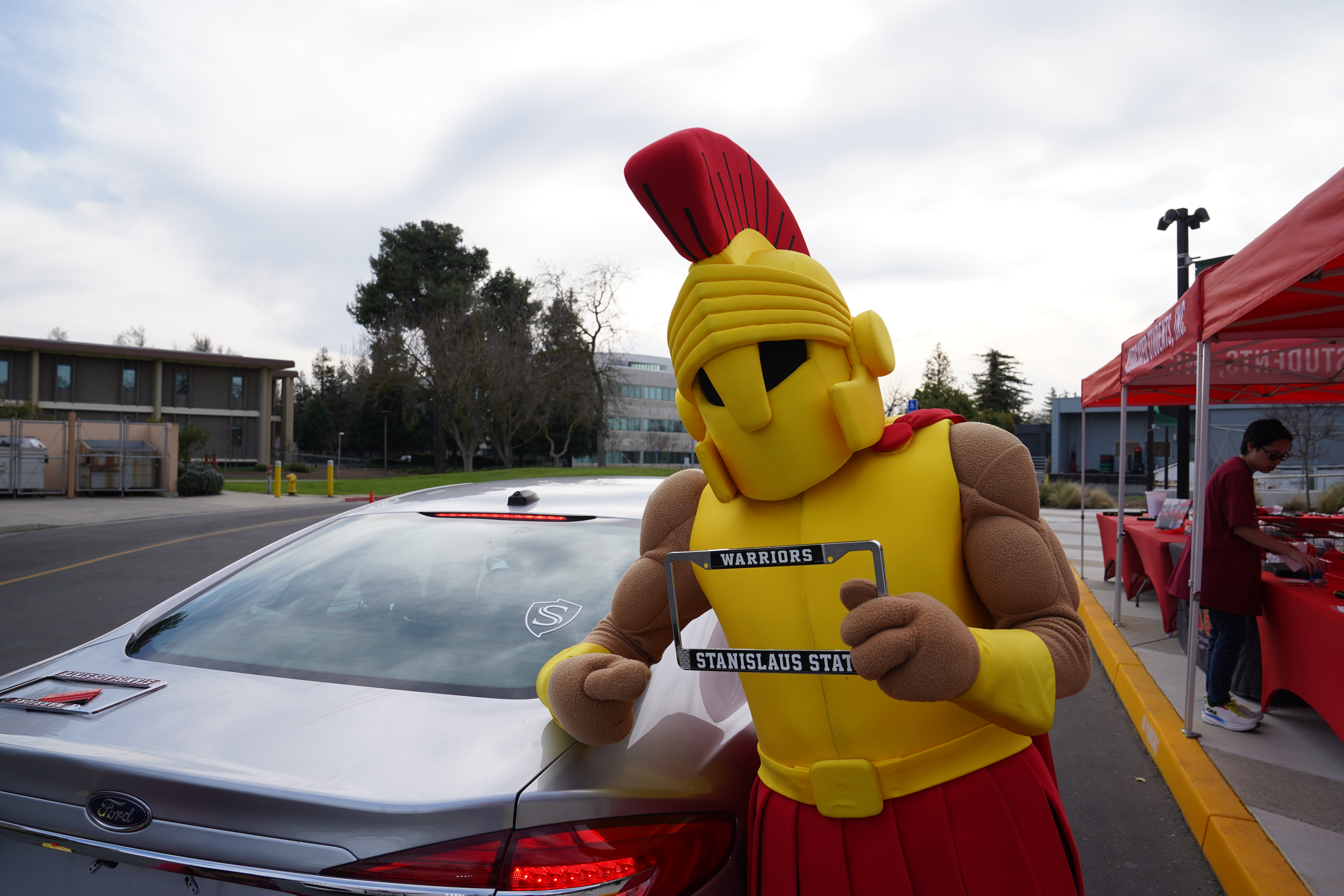 Titus posing next to car with Stan State license plate frame