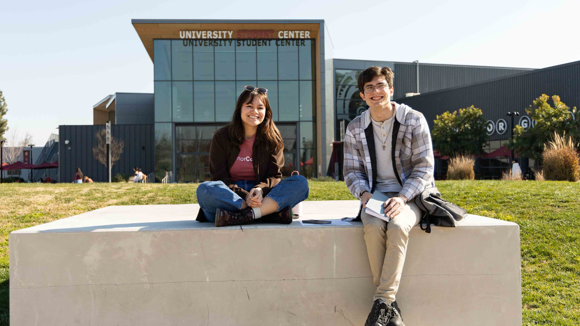 Two students sitting in front of the Student Center