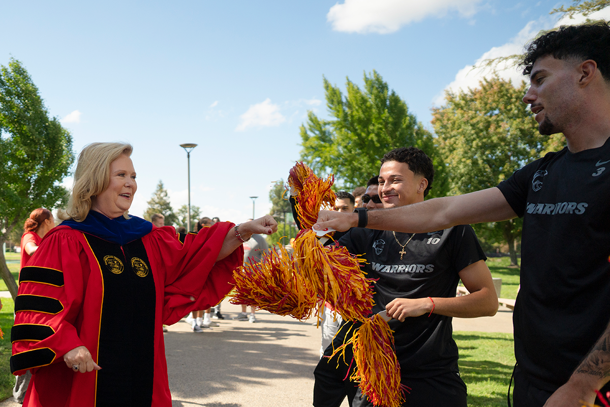 President Rios-Ellis greets students with a fist bump.